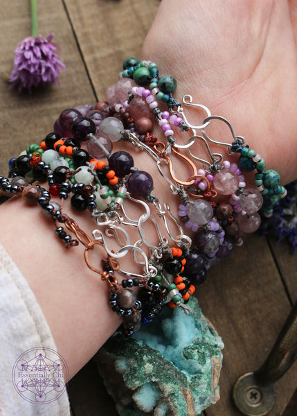 Hand-knotted beaded boho bracelets. Cord is nylon. Bracelets contain a gemstone bead with an S-curve of glass seed beads on one side or the other. Picture shows the hook clasps for each bracelet. Some are silver toned and a few are copper. See listing for each.