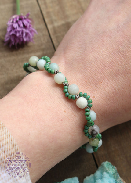 Handknotted beaded boho bracelet with nylon thread in the color grey. Gemstones are Amazonite. Seed beads are in an S curve on one side or the other of the gemstone in the color Sage green, Silver plated hook clasp.
