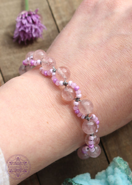 Handknotted beaded boho bracelet with nylon thread in the color grey. Gemstones are Strawberry Quartz (red aventurine). Seed beads are in an S curve on one side or the other of the gemstone in the color Light to dark pink. Silver plated hook clasp