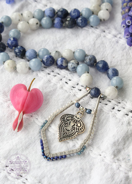 Hand-knotted boho necklace featuring rainbow moonstone, angelite, faceted sodalite, and dumortierite crystals with a silver-plated hook clasp and a beaded mandala pendant, perfect for opening the throat chakra.