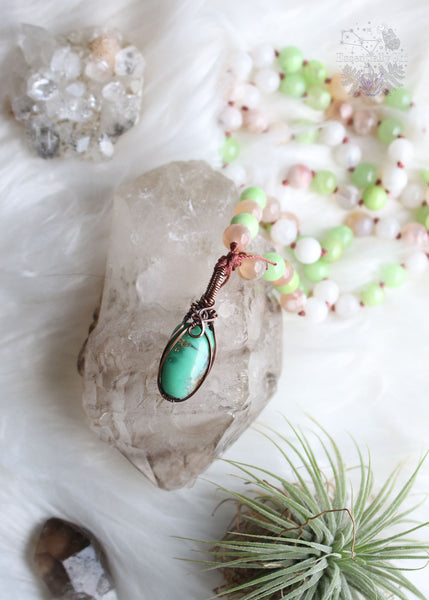 Embrace heart-centered healing with "The Heart Healer" Green Calcite & Chrysoprase Mala Necklace. Hand-knotted with green calcite, rainbow moonstone, and flower agate, it features a copper wire wrapped chrysoprase pendant. Slip it effortlessly over your head for mindful meditation, grounding, and heart chakra activation. Let this mala be your guide to self-love, aligning your heart with its true desires. Elevate your spiritual journey with this unique mala designed for emotional healing and love.