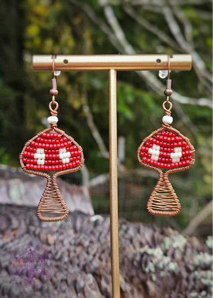 Copper Wire Wrapped mushroom earrings with a red and white beaded Amanita mushroom design. Dangle earrings on brass ear wires.