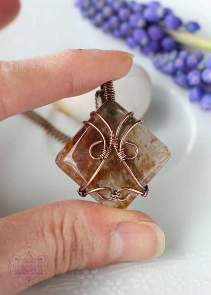 Indulge in the harmonious blend of strength and celestial beauty with our Hematite Garden Quartz Copper Wire Wrapped Necklace. The square-shaped garden quartz, resembling a wrapped package, showcases hematite inclusions, iridescent rainbows, and rutile. This handcrafted masterpiece promotes balance, protection, and a radiant connection to the divine. Perfect for Aries and Aquarius, this unique pendant aligns with the root and crown chakras, making it a symbol of grounding and spiritual elevation.