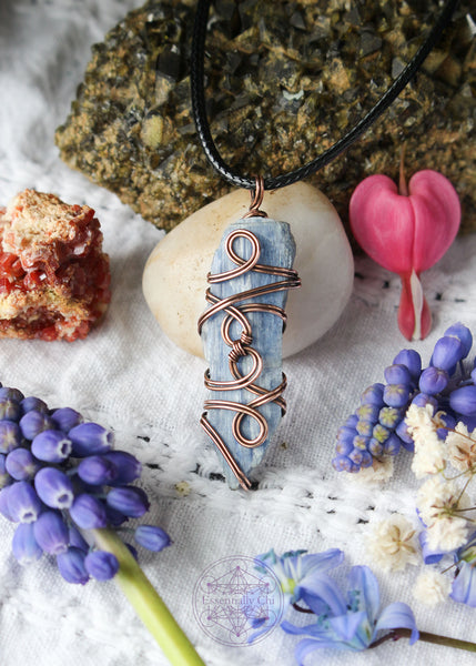 This copper wire wrapped pendant has 4 swirls along the face of the blue kyanite and is connecting the two middle swirls together. Raw Blue Kyanite Wire Wrapped Necklace for energy protection, featuring a simple, everyday wear design that enhances communication, alignment, tranquility, restful sleep, and dream recall.