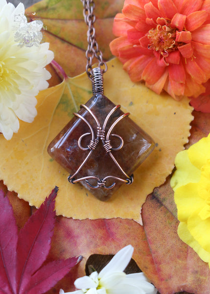 Indulge in the harmonious blend of strength and celestial beauty with our Hematite Garden Quartz Copper Wire Wrapped Necklace. The square-shaped garden quartz, resembling a wrapped package, showcases hematite inclusions, iridescent rainbows, and rutile. This handcrafted masterpiece promotes balance, protection, and a radiant connection to the divine. Perfect for Aries and Aquarius, this unique pendant aligns with the root and crown chakras, making it a symbol of grounding and spiritual elevation.