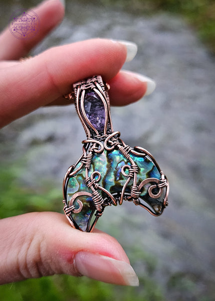 Abalone and Amethyst mermaid tail pendant wrapped in copper wire filagree design. The fin is an Abalone moon and the amethyst is faceted like the scales on the mermaid tail.