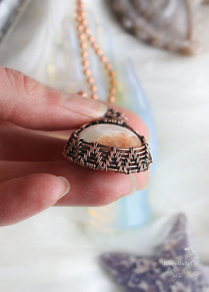 Elevate your spiritual style with our Peach Scolecite Copper Wire Wrapped Necklace. Delicately woven copper embraces a teardrop-shaped peach scolecite, accompanied by a pink jasper in the bail. This handcrafted masterpiece exudes calming energy, promoting emotional healing and spiritual upliftment. Perfect for Libra & Capricorn zodiacs, this necklace aligns with the crown and third eye chakras, fostering a sense of tranquility and connecting you to the divine feminine energy.