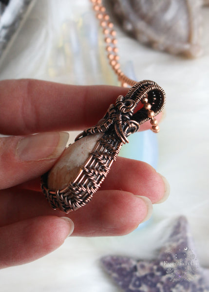 Elevate your spiritual style with our Peach Scolecite Copper Wire Wrapped Necklace. Delicately woven copper embraces a teardrop-shaped peach scolecite, accompanied by a pink jasper in the bail. This handcrafted masterpiece exudes calming energy, promoting emotional healing and spiritual upliftment. Perfect for Libra & Capricorn zodiacs, this necklace aligns with the crown and third eye chakras, fostering a sense of tranquility and connecting you to the divine feminine energy.