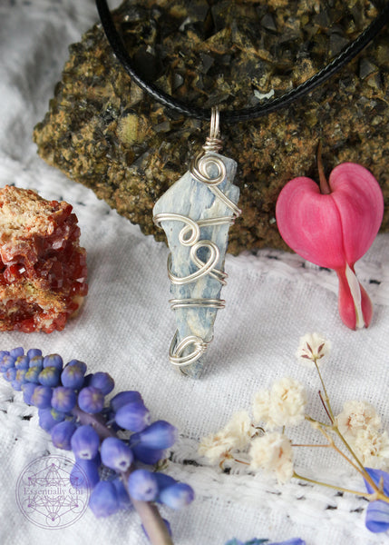 This silver plated wire wrapped pendant has 4 swirls along the face of the blue kyanite. This raw crystal is narrow at the bottom and wider at the top. Raw Blue Kyanite Wire Wrapped Necklace for energy protection, featuring a simple, everyday wear design that enhances communication, alignment, tranquility, restful sleep, and dream recall.