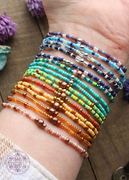 Beaded Stretchy Boho Stacker Bracelets all on the wrist to show available colors. This shows the backside where there's a copper or silver colored crimp bead to hide the knot.