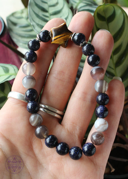 Shimmery and sparkly crystal stretch bracelet with a star shaped tiger eye focal bead, 8mm blue goldstone, and grey Botswana agate beads.