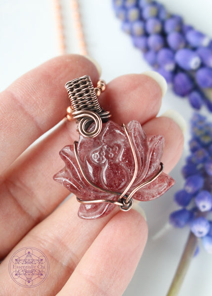 Tanzberry Lotus Copper Wire Wrapped Necklace featuring a carved lotus tanzberry that is very sparkly (red aventurine) crystal, wrapped in a simple copper wire that flows with the petals of the lotus. Pendant is 1.5" long on an 18" copper chain. Enhances determination, perseverance, and spiritual awakening. Shown in hand for size reference, 2.5 finger width long.