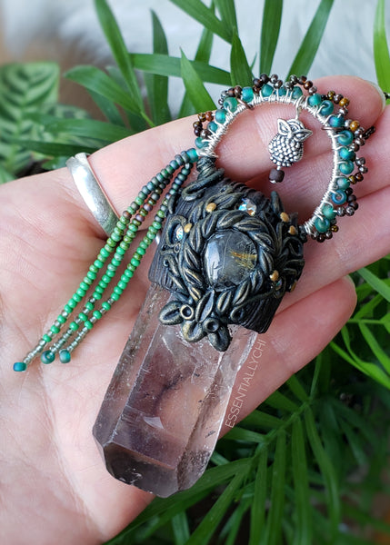 Shop the Garden Fairy Pendant. The Garden Fairy aesthetic is to remind you that when life gets tough, to get out in nature and see what Mother Gaia has given you. This beautiful raw smoky quartz point and rutilated tear drop center stone are paired together to help get you thru life's rough patches with ease. Smoky quartz helps transmute negative energy into positive and rutilated quartz helps you dig into shadow work gently and see the good in yourself. The owl stands for wisdom and protection.