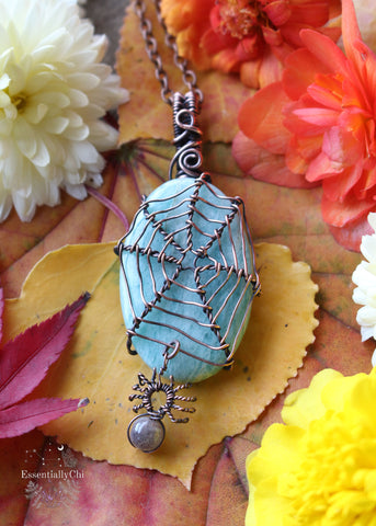 Handcrafted spider web copper wire-wrapped Amazonite gemstone pendant, featuring a black moonstone spider charm. A unique and mystical piece of jewelry.