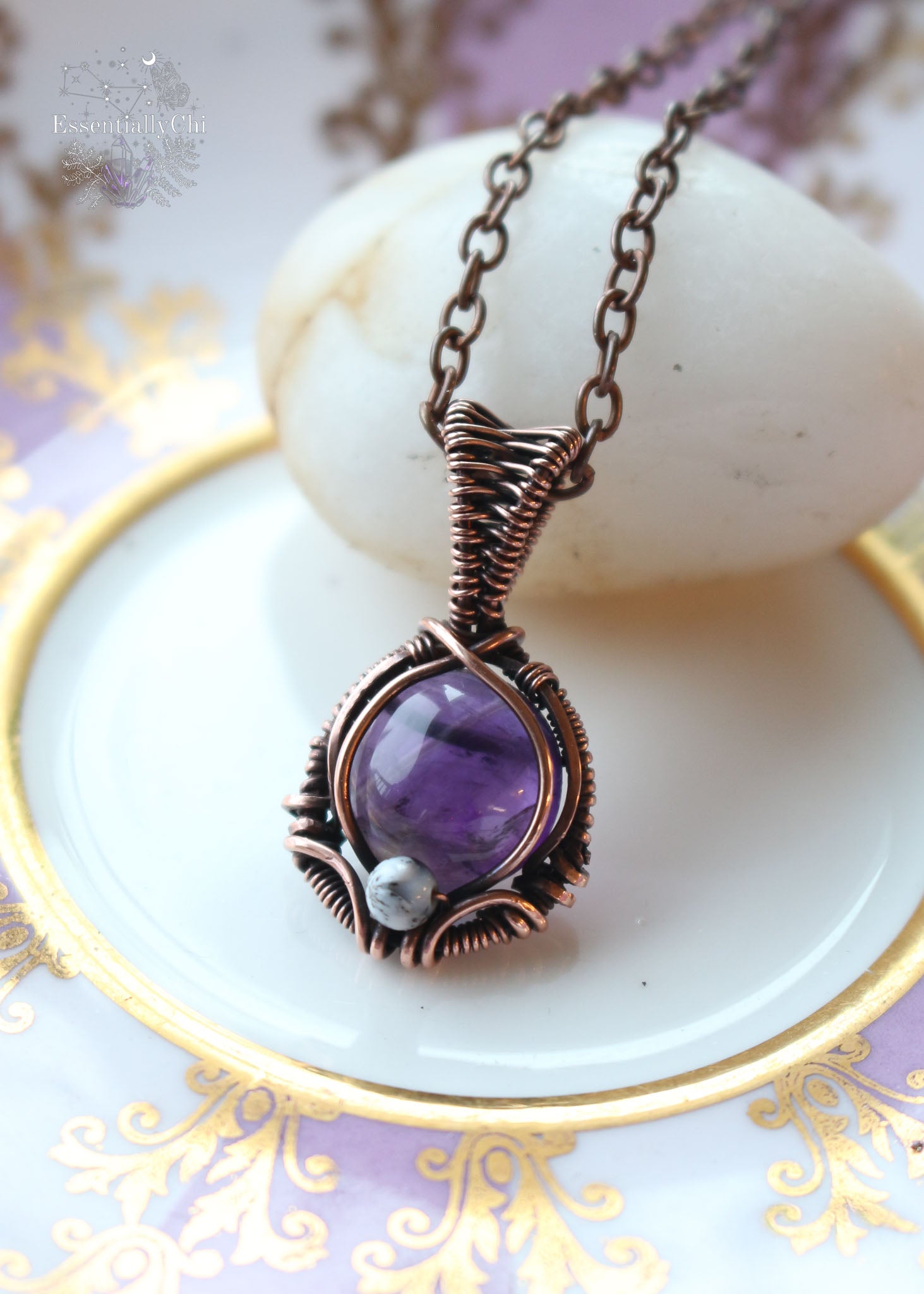 A mesmerizing Mystic Amethyst Noir Copper Necklace featuring a dark purple amethyst stone wrapped in copper wire, adorned with a dendritic opal accent bead. This handcrafted pendant hangs elegantly on an 18" copper chain, radiating spiritual energy and unique charm. Perfect for those seeking balance, tranquility, and a touch of bohemian elegance in their jewelry collection.