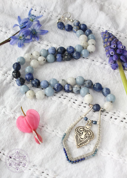 Hand-knotted boho necklace featuring rainbow moonstone, angelite, faceted sodalite, and dumortierite crystals with a silver-plated hook clasp and a beaded mandala pendant, perfect for opening the throat chakra.