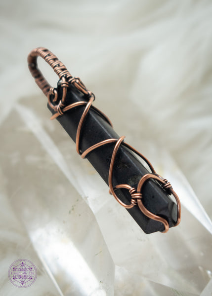 Black Tourmaline point wrapped in copper wire with a criss cross design up the front and a simple woven bail. This protection crystal is great for a minimalist and can be unisex. Shown sitting on clear quartz to highlight the pendnat.