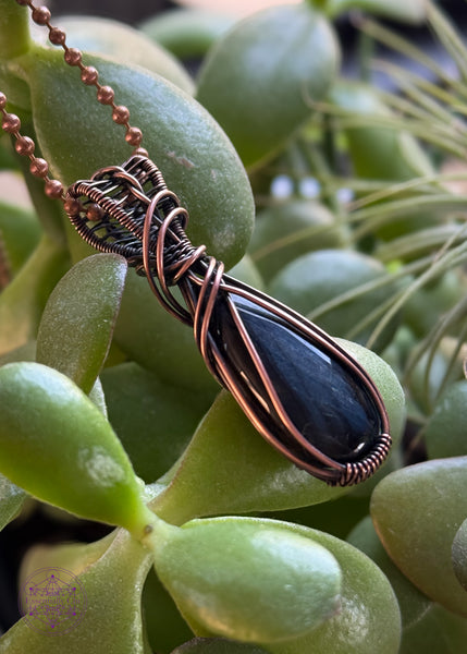 Chantoyant blue tiger eye crystal in a pear shaped cut wrapped in copper wire, simple framing and a twisted bail for everyday wear. 