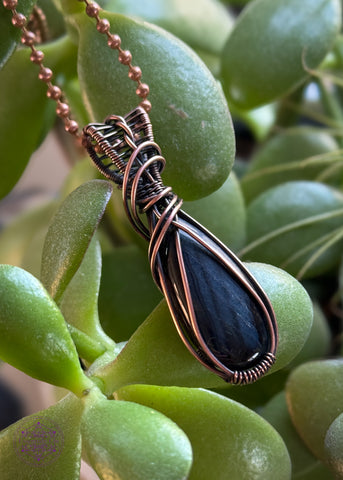 Chantoyant blue tiger eye crystal in a pear shaped cut wrapped in copper wire, simple framing and a twisted bail for everyday wear. 