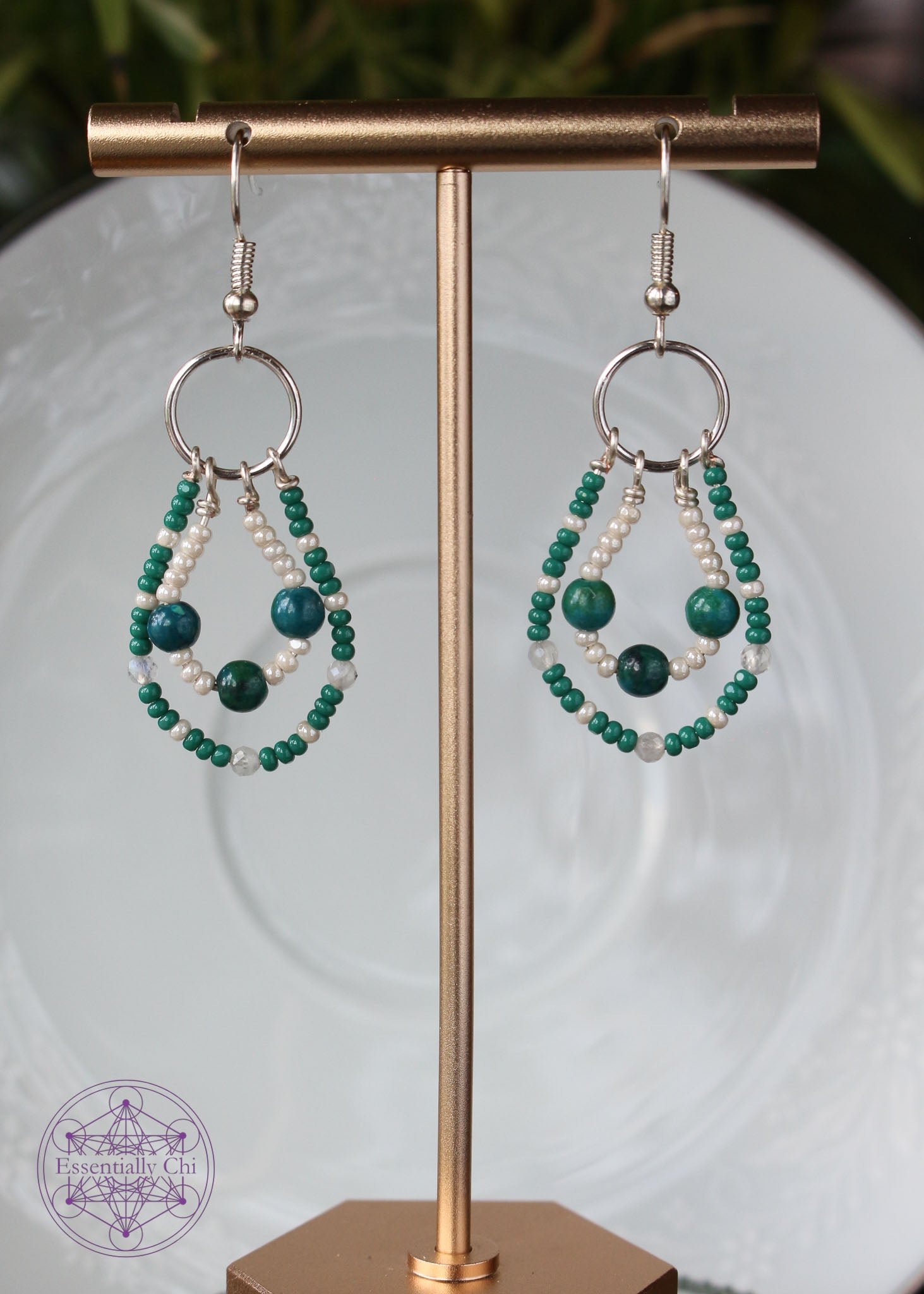 Chrysocolla and Moonstone Beaded Earrings featuring genuine chrysocolla & faceted moonstone beads, glass seed beads in a double loop design, 2" long with silver-toned brass ear hooks. outside loop is green seed beads and faceted moonstone beads, inside loop is pearl white seed beads with chrysocolla beads. 