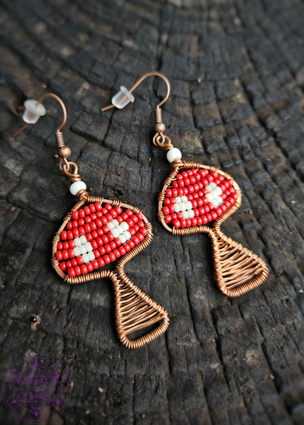 Copper Wire Wrapped mushroom earrings with a red and white beaded Amanita mushroom design. Dangle earrings on brass ear wires. 