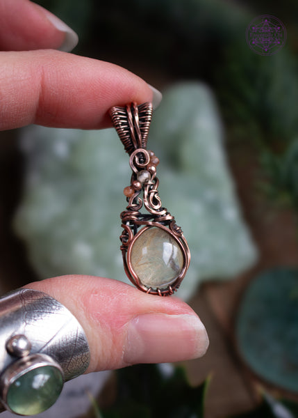 This copper wire wrapped pendant has a small round golden rutile crystal and accent crystal beads of sunstone and citrine that catch the light and really make this pendant sparkle like stardust! Shown in hand to see the details of the faceted beads and the golden rutile strands inside the quartz.