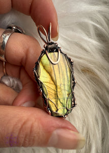 This Labradorite crystal coffin has beautiful hues of yellow, orange, and green, the perfect combo for autumn. Wrapped with a simple viking weave to show off most of the vibrant flash in the labradorite and a simple bail for those who like a minimal jewelry design. Shown in hand to display the range of color in the labradorite. 