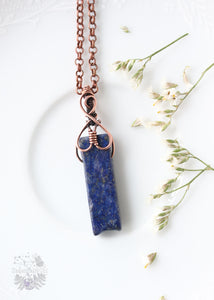Unleash the celestial energy of our Nuit Lapis Lazuli Copper Wire Wrapped Pendant. Inspired by the goddess Nuit, this piece enhances spiritual expansion, inner truth, and calming energies, making it an ideal companion for empaths seeking balance.