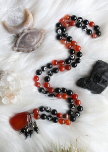 Ignite your inner strength with our "Burn the Bad Vibes" Obsidian and Carnelian Mala Necklace. This hand-knotted 72-bead mala, featuring rainbow obsidian, faceted carnelian, and protective evil eye beads, is a powerful companion for meditation and energy purification. With a chunky carnelian pendant, this necklace promotes creativity, vitality, and psychic protection. Elevate your spiritual journey with this unique mala designed for burning away negativity and fostering positive energy.