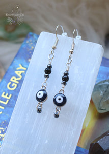 2-inch Black Onyx Evil Eye Dangle Beaded Earrings with a navy blue and silver-colored charm, hematite-colored beads, and customizable earring hooks in sterling silver, stainless steel, or niobium