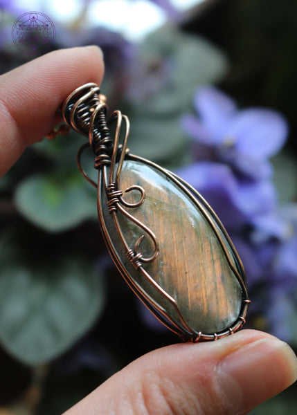 Orange Labradorite is a powerful stone of creativity, transformation, and emotional healing. It resonates with the Sacral and Solar Plexus Chakras, supporting emotional balance, creative expression, and personal empowerment. Oval cabochon shaped crystal with two swirls of copper coming over the left face and a simple design to show the bright orange flash.