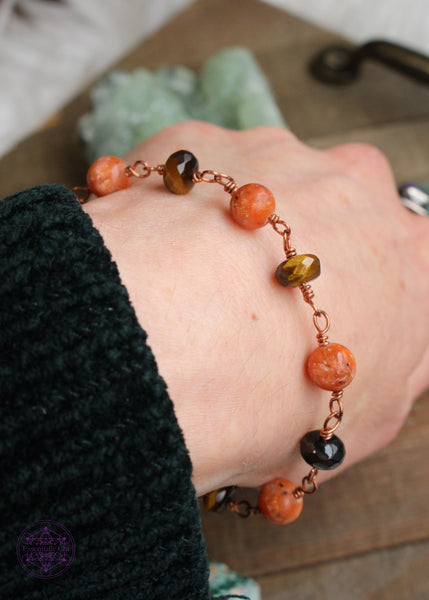 Copper wire wrapped bracelet features 8mm Orchid Calcite beads individually wrapped with faceted rondelle Tiger Eye beads individually wrapped linking together for an elegant bracelet. Shown on wrist to see how it lays. 