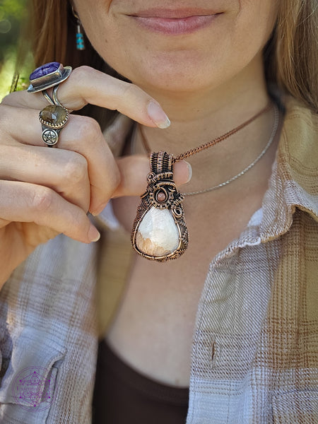 Peach scolecite wrapped in copper wire is shown worn around the neck and the neutral colors that go perfectly with the stone color. This piece traveled with me along the Oregon Coast.