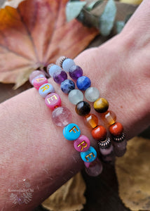A trio of Chakra Healing Stretch Bracelets crafted with a combination of powerful chakra stones including Red Jasper, Carnelian, Tiger Eye, Prehnite, Sodalite, Amethyst, Angelite, Pink Dyed Quartz, Jasper, and Strawberry Quartz. Each bracelet is designed to enhance energetic alignment and promote emotional well-being for empaths.