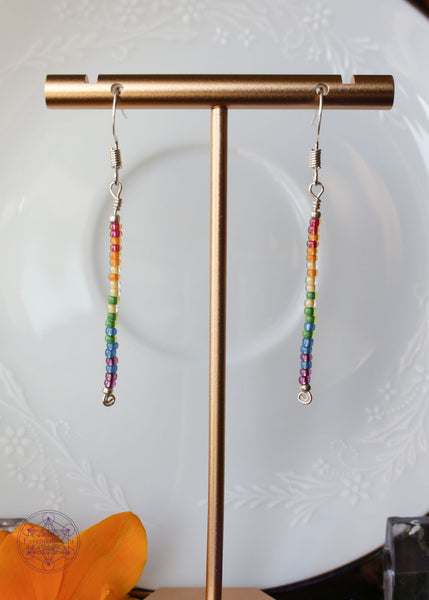 Pride Rainbow Earrings with seed bead drop design in rainbow pattern of red to purple on silver plated wire hanging 2.25" from silver toned ear wires.