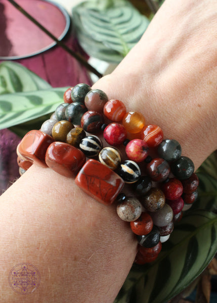 stack of grounding & protection crystal bracelets shown on wrist.