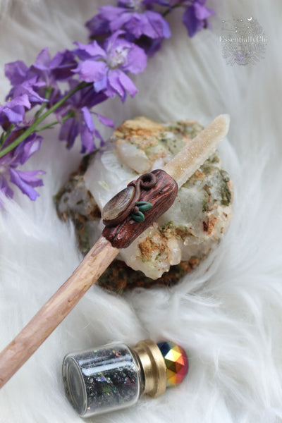 Unveil the enchantment of simplicity with our artisan-carved crystal wand. Crafted from cherry plum wood, adorned with polymer clay tree bark and leaves. Embrace the elegance of a teardrop rutilated quartz and spirit quartz tip. Classic Harry Potter style meets woodland magic in this timeless wand. #ArtisanCrystalWand #WoodlandEnchantment crystal wands for energy work. polymer clay crystal wand, wizzard wand, cosplay magical wand, polymer clay wand, crystal magic. 