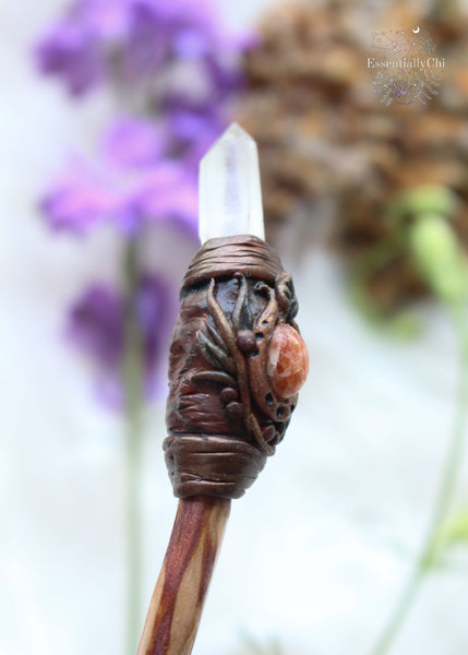 Elevate your energy with our handcrafted crystal wand, a fusion of Sunstone's radiant warmth & Lemurian Quartz's enlightening clarity. Infused with intention & artistry, this wand invites transformation & empowerment into your journey. Crafted from our cherry plum tree, this wand showcases a woodland-inspired polymer clay tip adorned with crystals. The handcarved handle ensures a comfortable grip. Unveil the magic within & wield your own enchanted wand, reminiscent of Harry Potter's world.