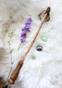Dive into the realm of woodland enchantment with our handmade crystal wand, adorned with sculpted polymer clay vines and moss, echoing the mystical forest. Embellished with Brazilian tangerine quartz, garnet, and jade crystals, it resonates with vitality, passion, & serenity. A rainbow moonstone at the base of the handle adds a touch of moonlit magic. Elevate your cosplay, energy work, & crystal grids with this versatile wand that enchants any space. #CrystalWand #CrystalMagic Harry potter wand