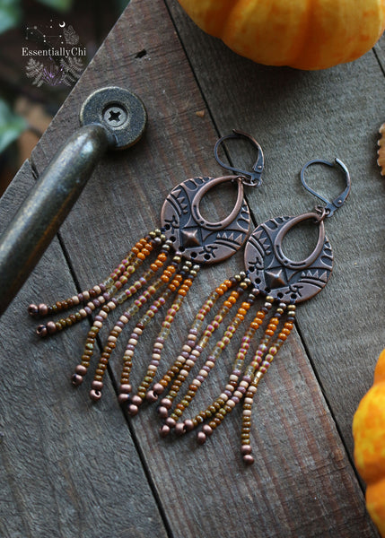 Tree Spirit Copper Fringe Earrings, 3 inches in length with a gradient of brown seed beads and a boho copper charm. Secured with copper lever-back ear wires, these earrings offer handmade elegance with a touch of woodland whimsy