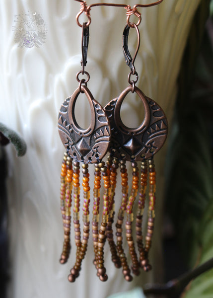 Tree Spirit Copper Fringe Earrings, 3 inches in length with a gradient of brown seed beads and a boho copper charm. Secured with copper lever-back ear wires, these earrings offer handmade elegance with a touch of woodland whimsy