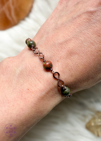 Copper wire wrapped bracelet features 6mm Unakite beads individually wrapped with figure 8 Infinity links in-between for an elegant bracelet. Shown on wrist to see how it lays. 
