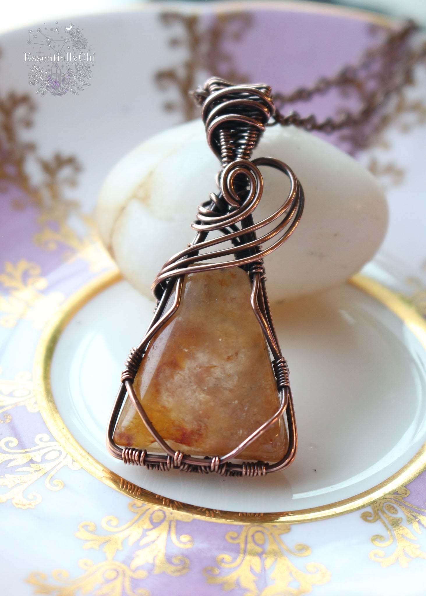 Nebu Orange Aventurine Copper Wire Wrapped Necklace - A captivating triangle-shaped pendant inspired by ancient Egyptian motifs, featuring a three-swoop bail design. The orange aventurine sparkles with golden hues, reminiscent of a radiant sunset. This handcrafted necklace, 2 inches in length, hangs gracefully from a 20-inch copper chain, symbolizing creativity, confidence, and the warm embrace of celestial energies.